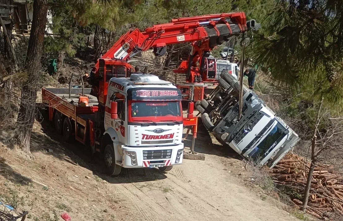 Adana’da tomruk taşıyan kamyon şarampole devrildi, sürücü yaralı kurtarıldı.