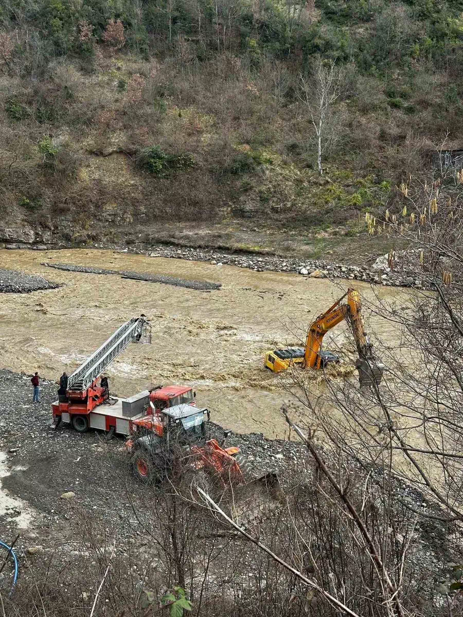 Çayın debisi yükselince iş makinesinin üzerinde mahsur kalan operatör kurtarıldı.