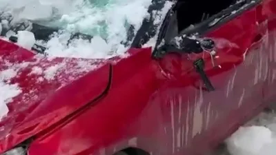 Erzurum'un Palandöken ilçesinde çatıdan düşen kar kütlesi, park halindeki otomobile