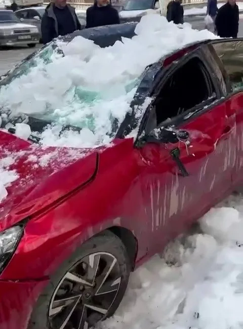 Erzurum'un Palandöken ilçesinde çatıdan düşen kar kütlesi, park halindeki otomobile