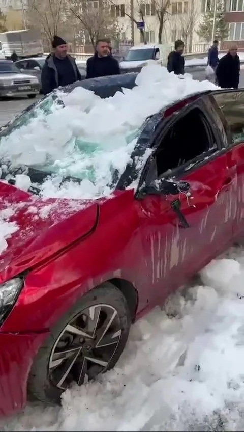 Erzurum'un Palandöken ilçesinde çatıdan düşen kar kütlesi, park halindeki otomobile