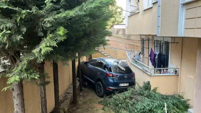 Gebze'de araç geri manevra yaparken duvarı aşıp binanın bahçesine düştü.