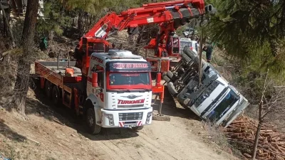 Adana'da tomruk taşıyan kamyon şarampole devrildi, sürücü yaralı kurtuldu. Kazanın