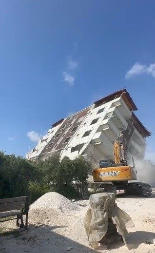 Hatay’ın Defne ilçesinde 7 katlı binanın iş makinesinin darbesiyle yerle