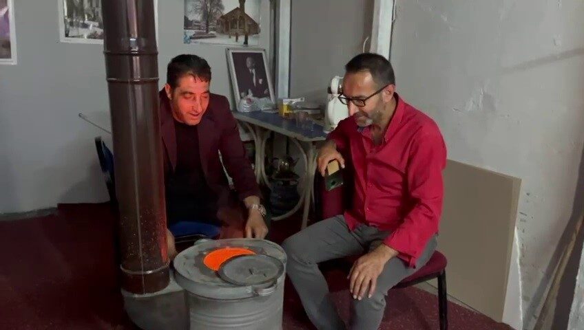 Erzurum’da bir esnaf, temmuz ayında yaşanan soğuk nedeniyle soba yaktı.