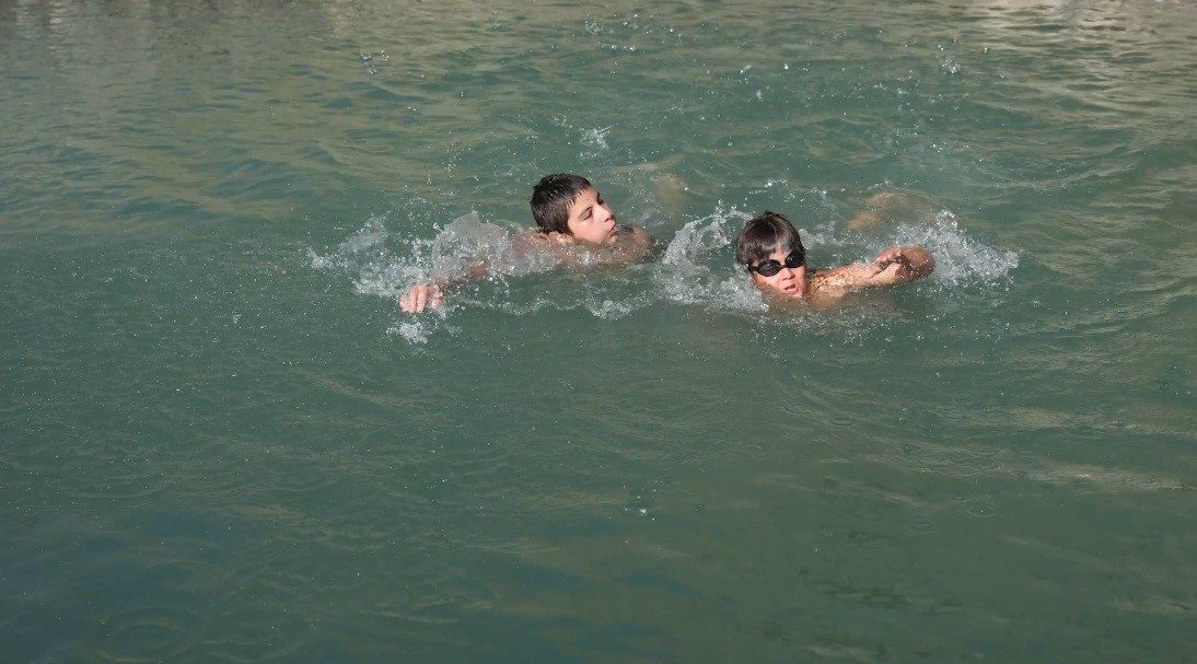 Erzincan’ın Üzümlü ilçesinde sıcak havadan bunalan çocuklar, derede suya girerek