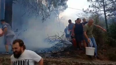 Kocaeli’nin İzmit ilçesinde ormanlık alanda çıkan yangına mahalleli kovalarla müdahale