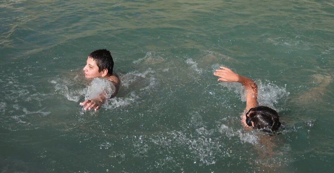 Erzincan’ın Üzümlü ilçesinde etkisini sürdüren sıcak hava nedeniyle çocuklar, dere